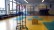 In der Gymnastikhalle sind verschiedene Sportgeräte aufgebaut wie zum Beispiel ein Trampolin und ein Mini-Basketballkorb.