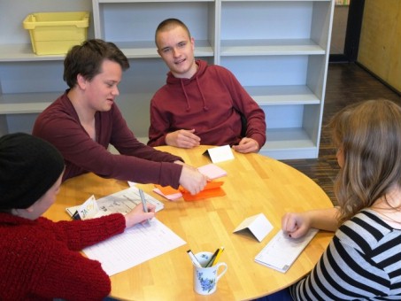 Das Foto zeigt vier Schülerinnen und Schüler beim Arbeitstreffen der Streitschlichter an einem runden Tisch.