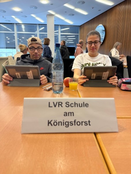 Das Bild zeigt zwei Schüler*innen im Kreissaal des Rheinisch-Bergischen-Kreises. Sie bearbeiten eine Aufgabe am iPad