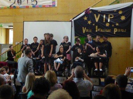 Das Foto zeigt die Abschluss-Schülerinnen und -Schüler mit einheitlichen, schwarzen T-Shirts bekleidet auf der Bühne vor dem Motto-Plakat.