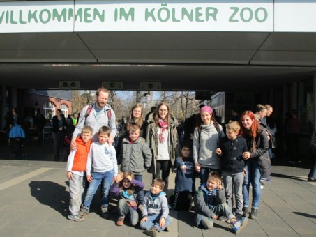 Auf dem Foto sieht man die Schülerinnen und Schüler und Begleiterinnen und Begleiter vor dem Haupteingang des Kölner Zoos.
