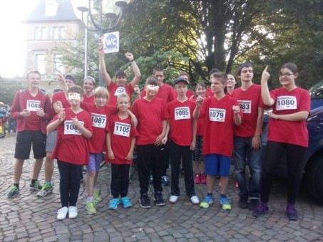 Dieses Foto zeigt Schülerinnen und Schüler der LVR-Schule am Königsforst in roten Laufshirts vor dem Lauf.