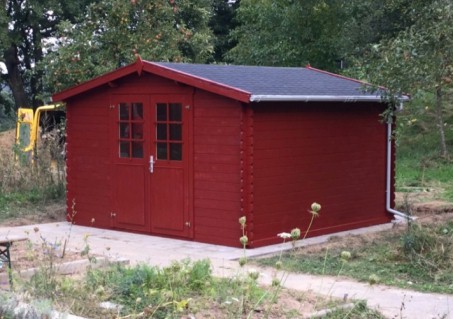 Das Foto zeigt das errichtete und rot gestrichene Gartenhaus.