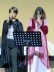 Zwei Schülerinnen stehen mit Mikrofonen in der Hand verkleidet auf der Bühne und singen.