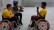 Zwei Schüler im Rollstuhl und Trikot, einer mit einem Mikrofon in der Hand, werden bei einem Interview von einem Fotografen gefilmt.