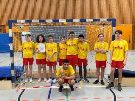 Foto: Schüler*innen in Trikots in der Sporthalle.