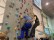 Foto: Ein Schüler klettert mit einer Kletterassistentin an der Kletterwand.
