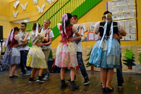 Das Foto zeigt vier slowakische Tanzpaare in Trachten bei der Aufführung.