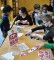 Das Foto zeigt Schülerinnen und Schüler, die Puzzleteile von verschiedenen Siegeln des fairen Handels zusammensetzen. 