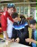 Das Foto zeigt drei Schüler in einem Betrieb, die versuchen, verschiedene Einzelteile zu montieren.