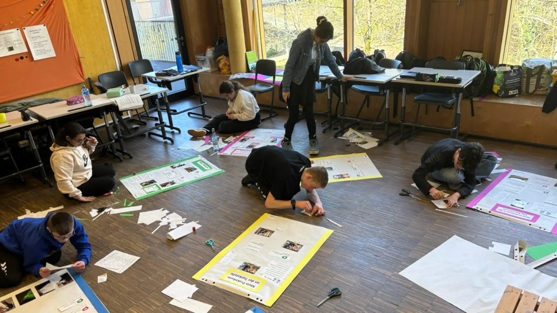 Schüler*innen bei der Arbeit an ihren Plakaten